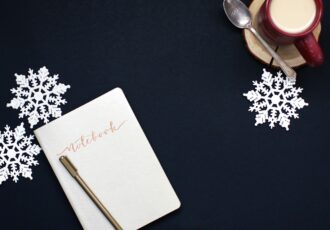 24 choses à faire en décembre pour sa thèse : entre magie des fêtes et élan académique – notebook - carnet - flocons - neige - tasse de lait chaud - café