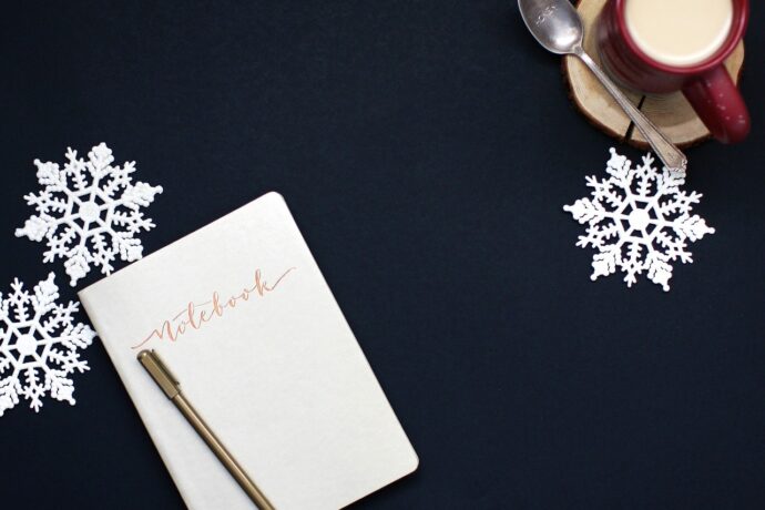 24 choses à faire en décembre pour sa thèse : entre magie des fêtes et élan académique – notebook - carnet - flocons - neige - tasse de lait chaud - café