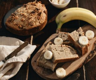 Cake à la banane et aux noix sur planche à découper avec couteau et banane