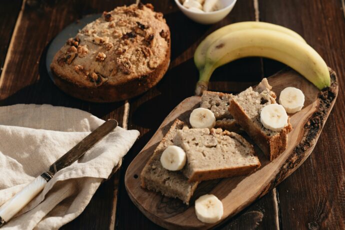 Cake à la banane et aux noix sur planche à découper avec couteau et banane