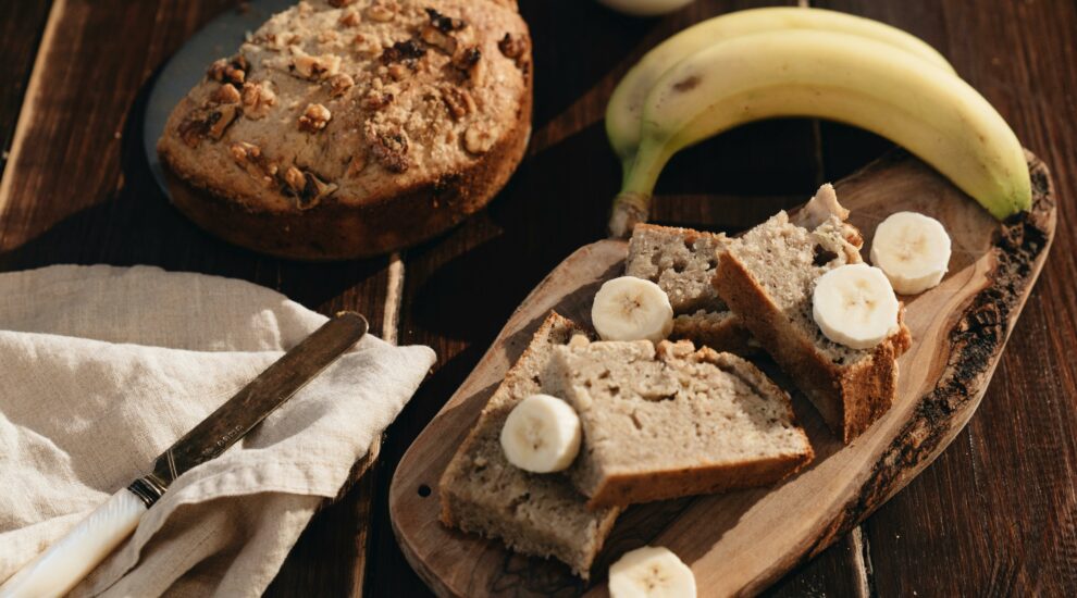 Cake à la banane et aux noix sur planche à découper avec couteau et banane